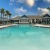a swimming pool with chairs and a building in the background